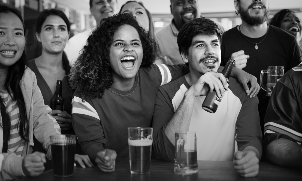 Back and white photo of happy people watching a game